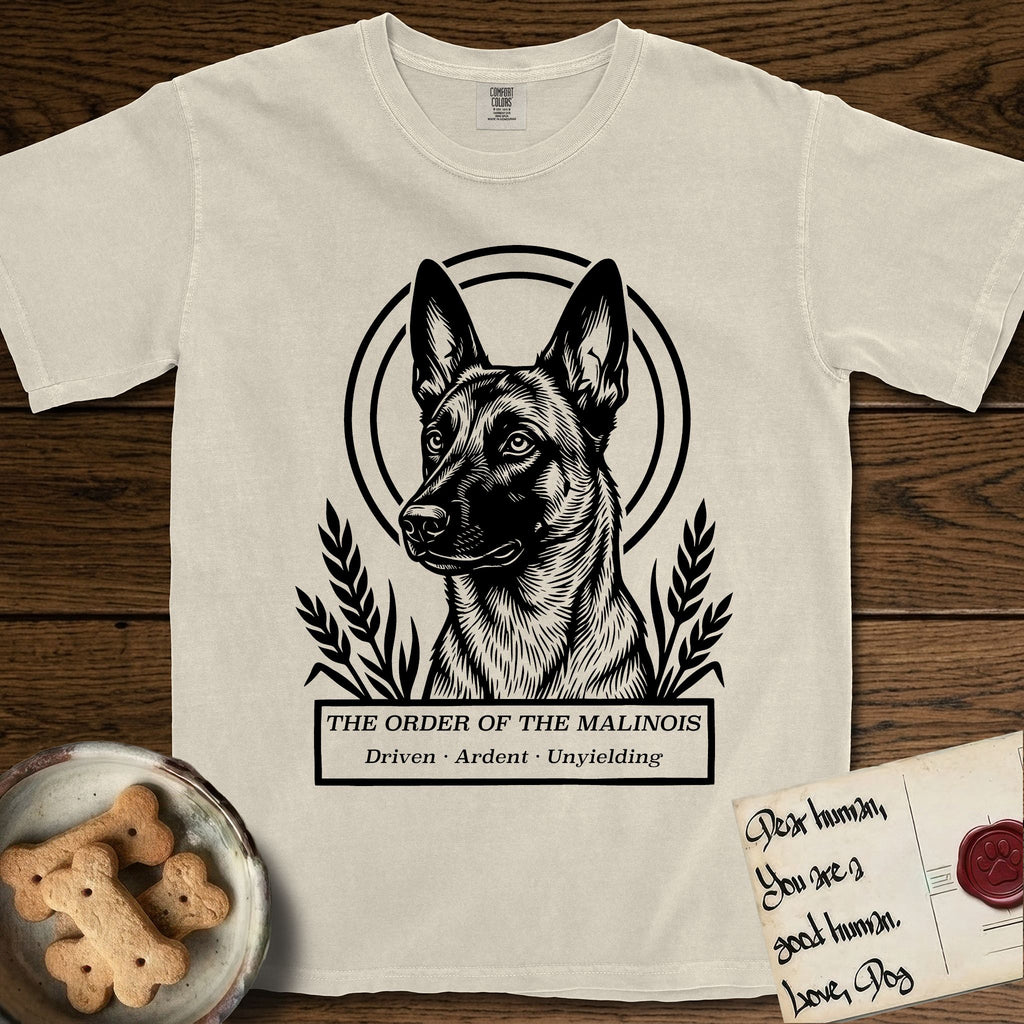 Holy Orders Belgian Malinois T-Shirt flat lay in Ivory, featuring a bold black-and-white linocut saint-medallion portrait of a Belgian Malinois.