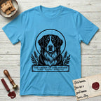 Holy Orders Bernese Mountain Dog T-Shirt flat lay in Sky, featuring a bold black-and-white linocut saint-medallion portrait of a Bernese Mountain Dog.
