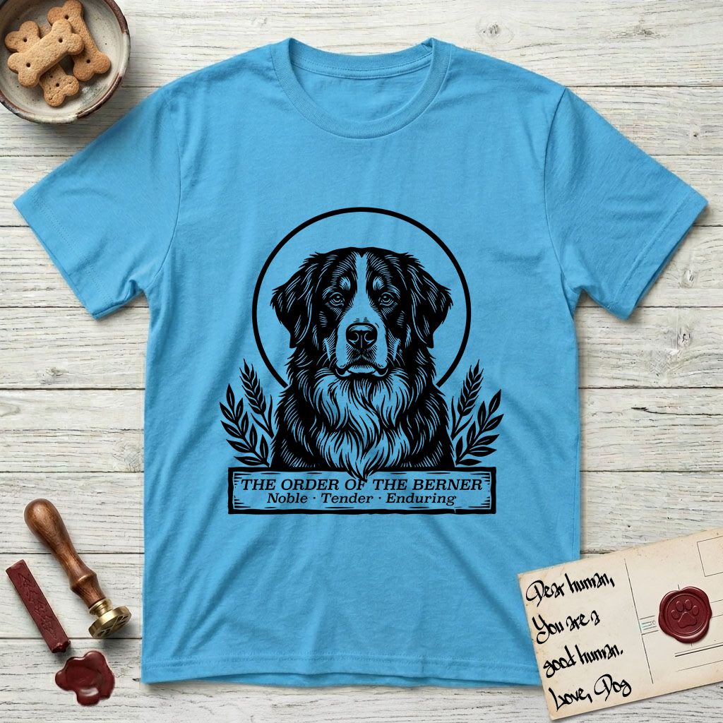 Holy Orders Bernese Mountain Dog T-Shirt flat lay in Sky, featuring a bold black-and-white linocut saint-medallion portrait of a Bernese Mountain Dog.