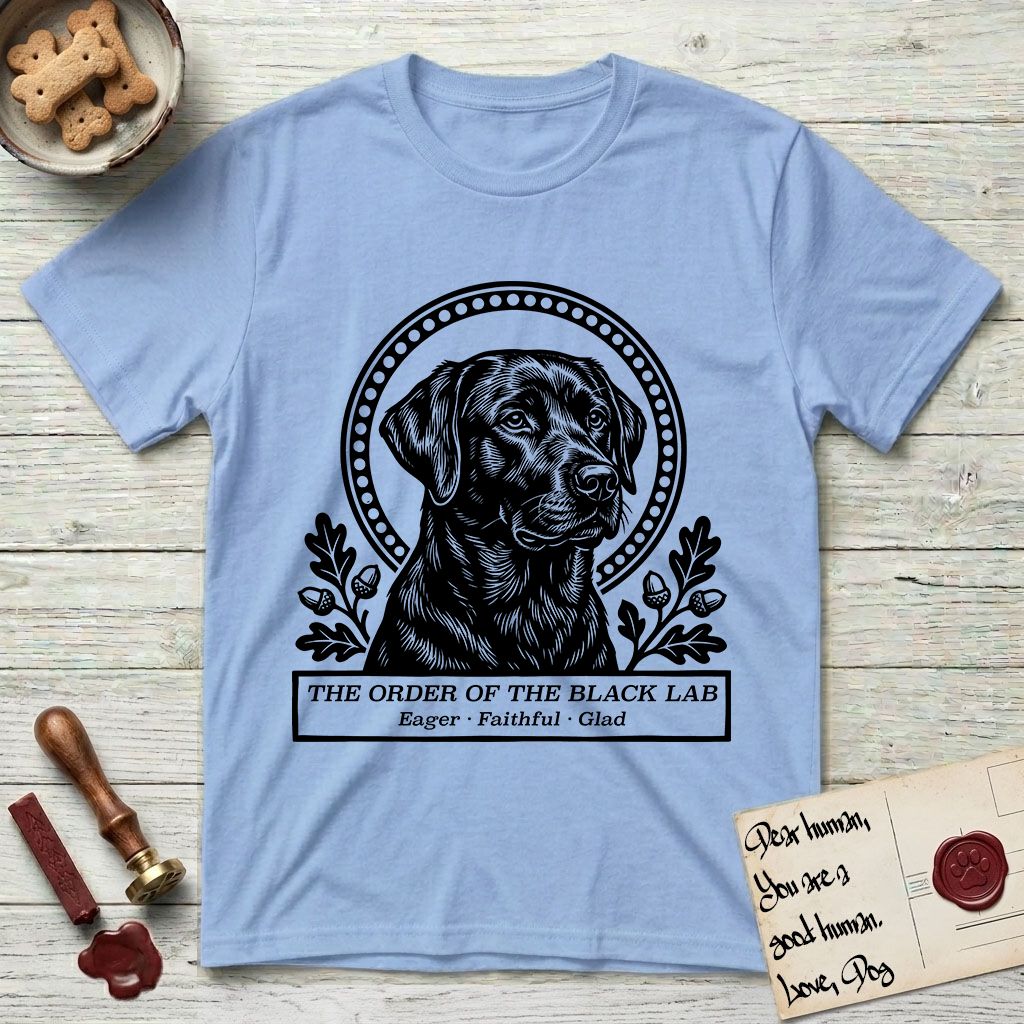 Holy Orders Black Lab T-Shirt flat lay in Light Blue, featuring a bold black-and-white linocut saint-medallion portrait of a Black Lab.