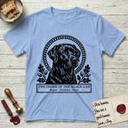 Holy Orders Black Lab T-Shirt flat lay in Light Blue, featuring a bold black-and-white linocut saint-medallion portrait of a Black Lab.