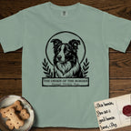 Holy Orders Border Collie T-Shirt flat lay in Bay, featuring a bold black-and-white linocut saint-medallion portrait of a Border Collie.