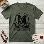 Holy Orders Border Collie T-Shirt flat lay in Heather Military Green, featuring a bold black-and-white linocut saint-medallion portrait of a Border Collie.