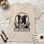 Holy Orders Border Collie T-Shirt flat lay in Sand, featuring a bold black-and-white linocut saint-medallion portrait of a Border Collie.