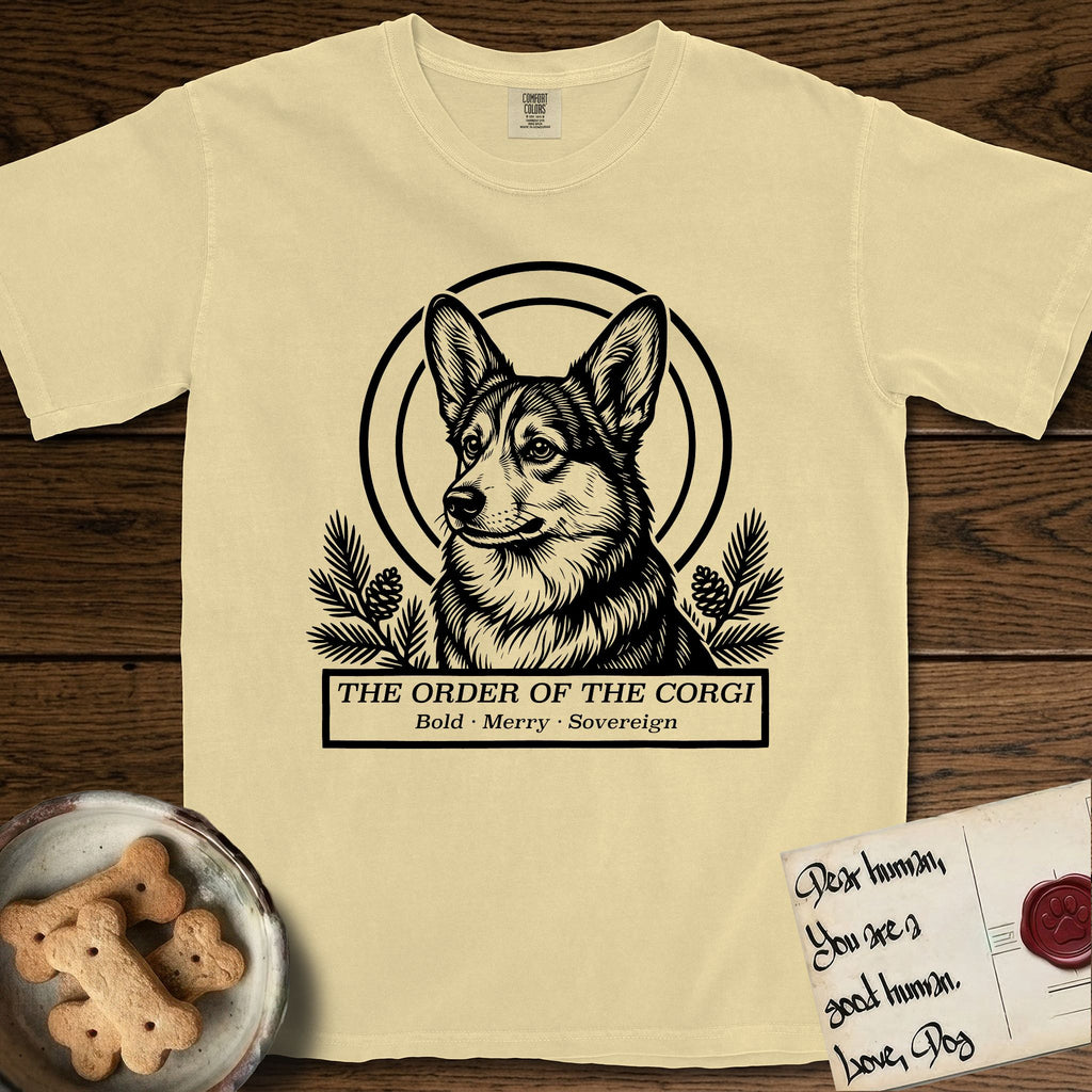 Holy Orders Corgi T-Shirt flat lay in Butter, featuring a bold black-and-white linocut saint-medallion portrait of a Corgi.
