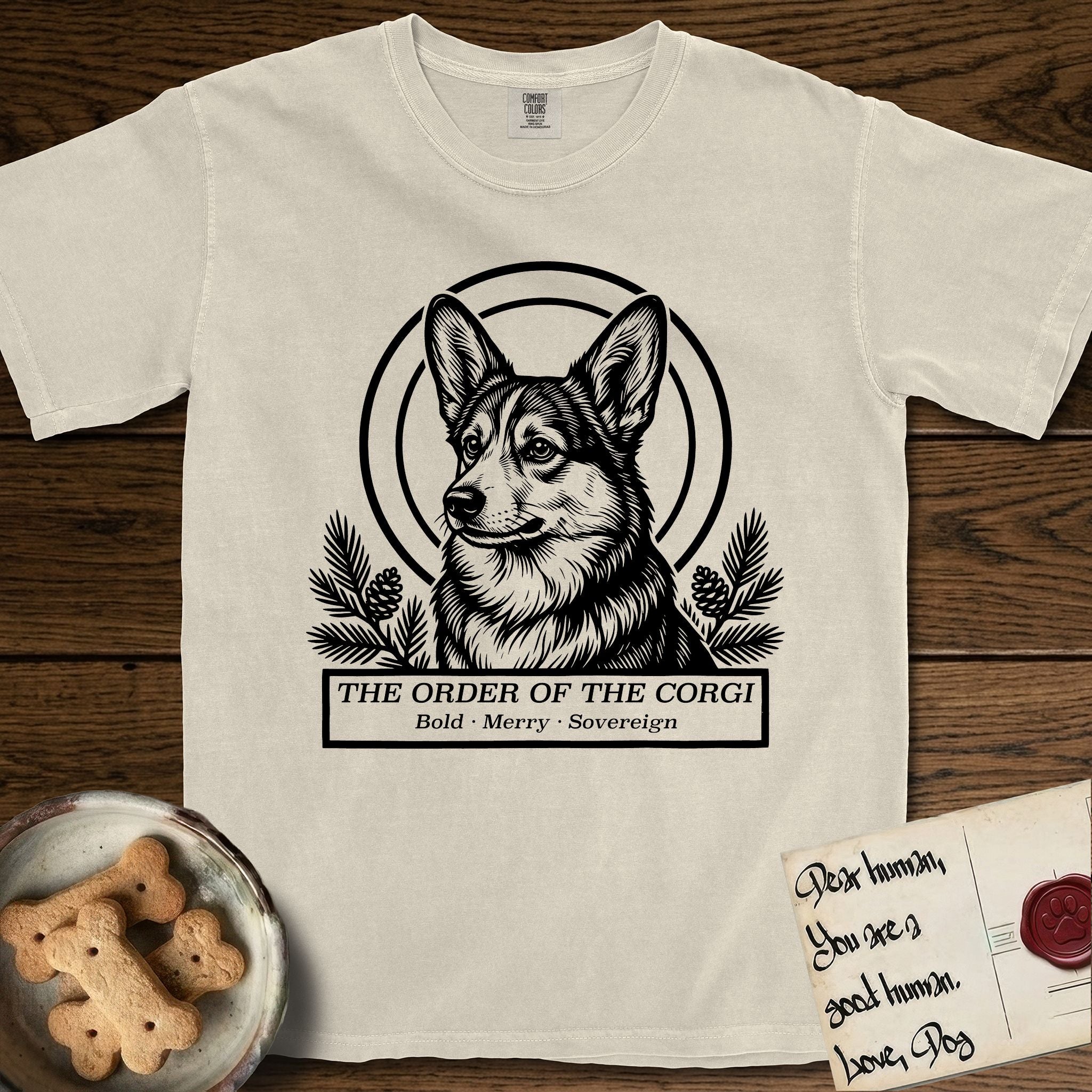 Holy Orders Corgi T-Shirt flat lay in Ivory, featuring a bold black-and-white linocut saint-medallion portrait of a Corgi.