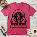 Holy Orders Dachshund T-Shirt flat lay in Heather Red, featuring a bold black-and-white linocut saint-medallion portrait of a Dachshund.