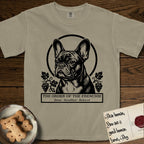 Holy Orders French Bulldog T-Shirt flat lay in Khaki, featuring a bold black-and-white linocut saint-medallion portrait of a French Bulldog.