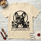 Holy Orders French Bulldog T-Shirt flat lay in Natural, featuring a bold black-and-white linocut saint-medallion portrait of a French Bulldog.
