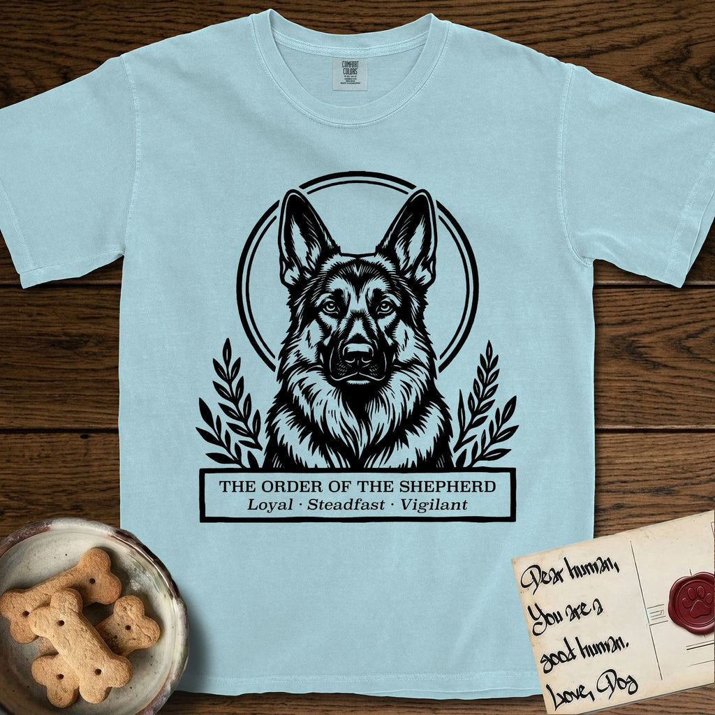 Holy Orders German Shepherd T-Shirt flat lay in Chambray, featuring a bold black-and-white linocut saint-medallion portrait of a German Shepherd.