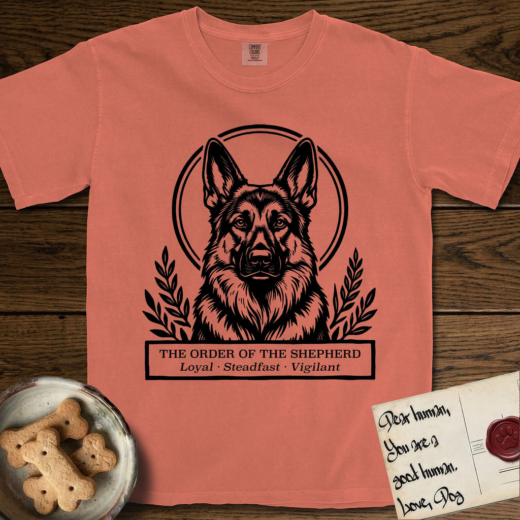 Holy Orders German Shepherd T-Shirt flat lay in Terracotta, featuring a bold black-and-white linocut saint-medallion portrait of a German Shepherd.