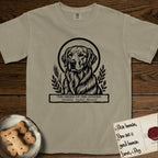 Holy Orders Golden Retriever T-Shirt flat lay in Khaki, featuring a bold black-and-white linocut saint-medallion portrait of a Golden Retriever.