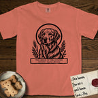 Holy Orders Golden Retriever T-Shirt flat lay in Terracotta, featuring a bold black-and-white linocut saint-medallion portrait of a Golden Retriever.