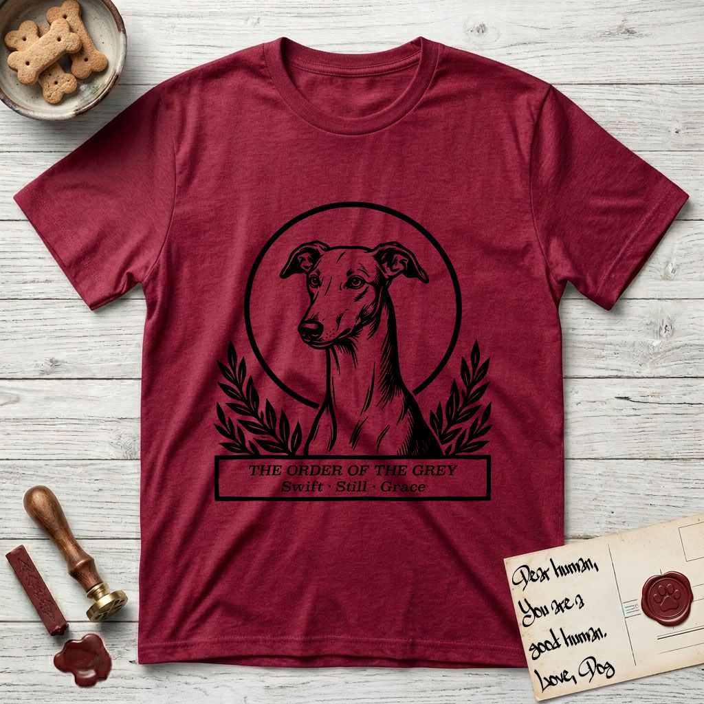 Holy Orders Greyhound T-Shirt flat lay in Antique Cherry Red, featuring a bold black-and-white linocut saint-medallion portrait of a Greyhound.