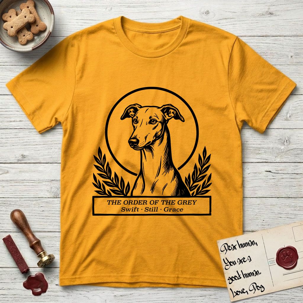 Holy Orders Greyhound T-Shirt flat lay in Gold, featuring a bold black-and-white linocut saint-medallion portrait of a Greyhound.