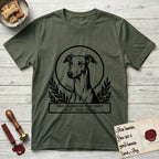 Holy Orders Greyhound T-Shirt flat lay in Heather Military Green, featuring a bold black-and-white linocut saint-medallion portrait of a Greyhound.