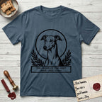 Holy Orders Greyhound T-Shirt flat lay in Indigo Blue, featuring a bold black-and-white linocut saint-medallion portrait of a Greyhound.