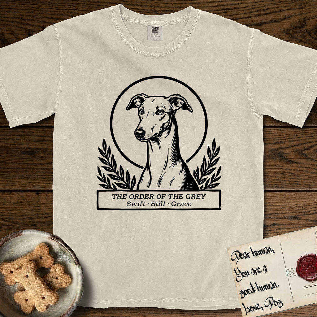 Holy Orders Greyhound T-Shirt flat lay in Ivory, featuring a bold black-and-white linocut saint-medallion portrait of a Greyhound.
