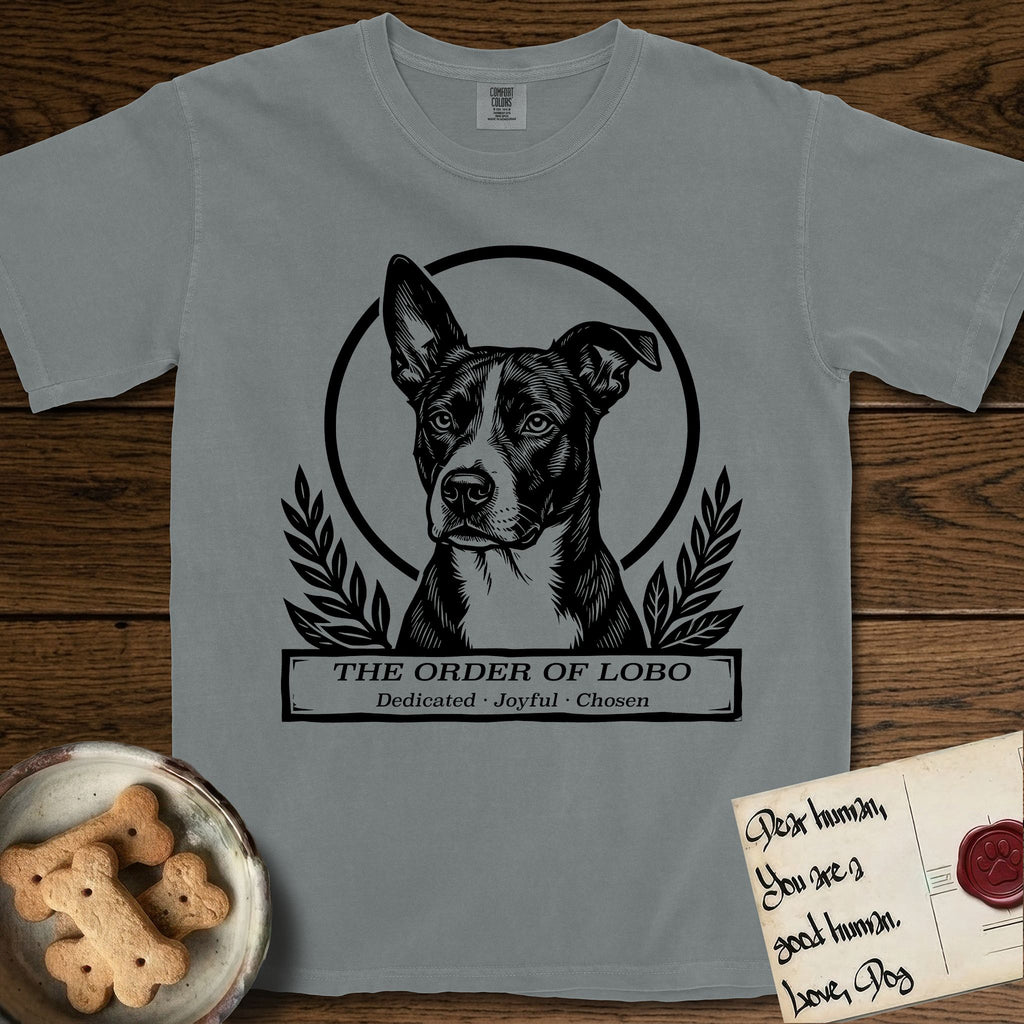 Holy Orders Lobo T-Shirt flat lay in Granite, featuring a bold black-and-white linocut saint-medallion portrait of Lobo, an Australian Cattle Dog and Pitbull mix with a white facial blaze.