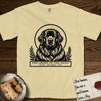 Holy Orders Newfoundland T-Shirt flat lay in Butter, featuring a bold black-and-white linocut saint-medallion portrait of a Newfoundland.
