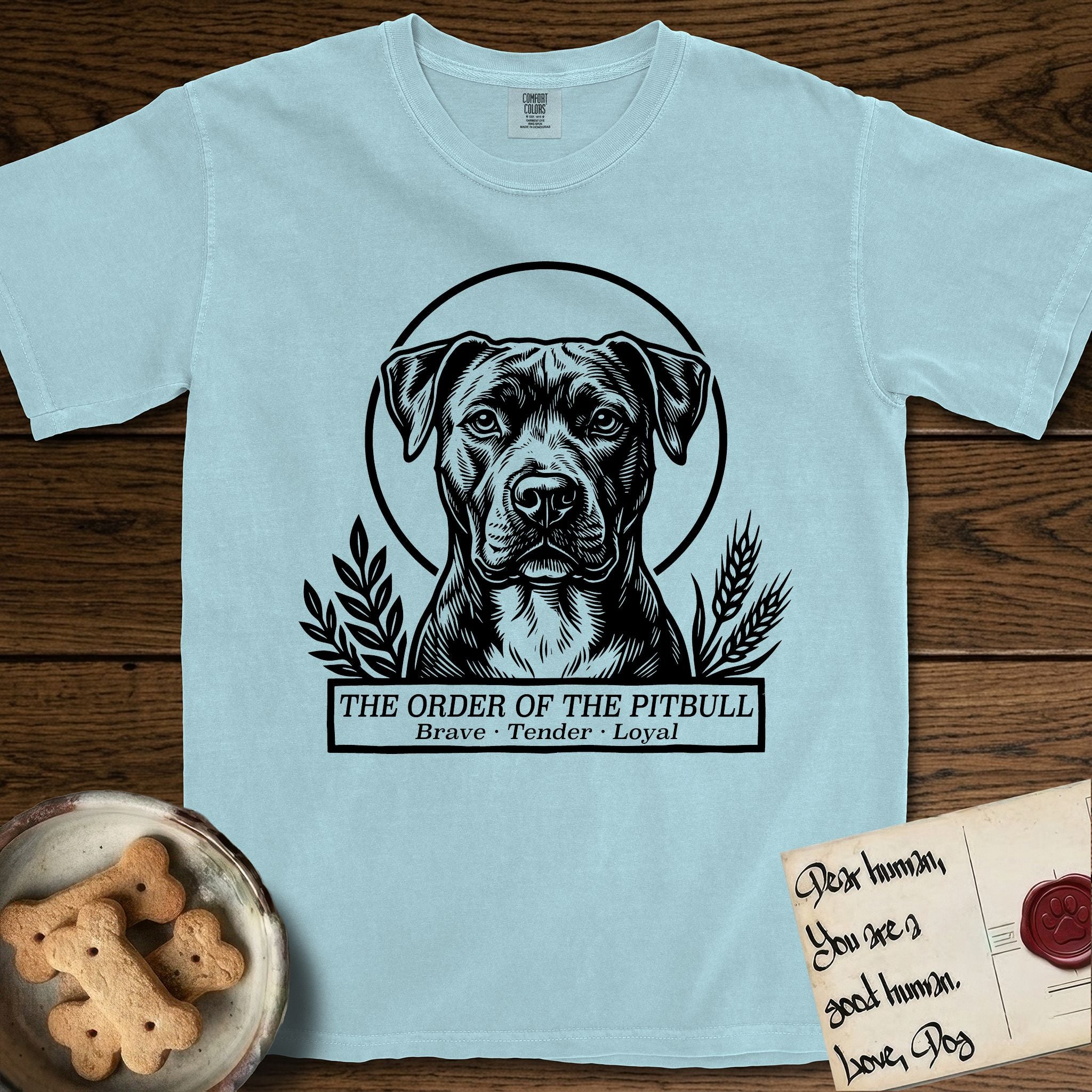 Holy Orders Pitbull T-Shirt flat lay in Chambray, featuring a bold black-and-white linocut saint-medallion portrait of a Pitbull.