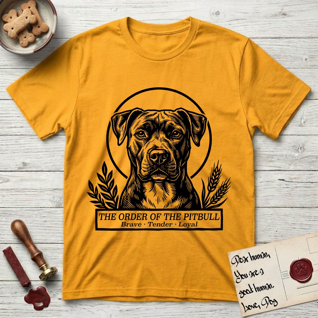 Holy Orders Pitbull T-Shirt flat lay in Gold, featuring a bold black-and-white linocut saint-medallion portrait of a Pitbull.