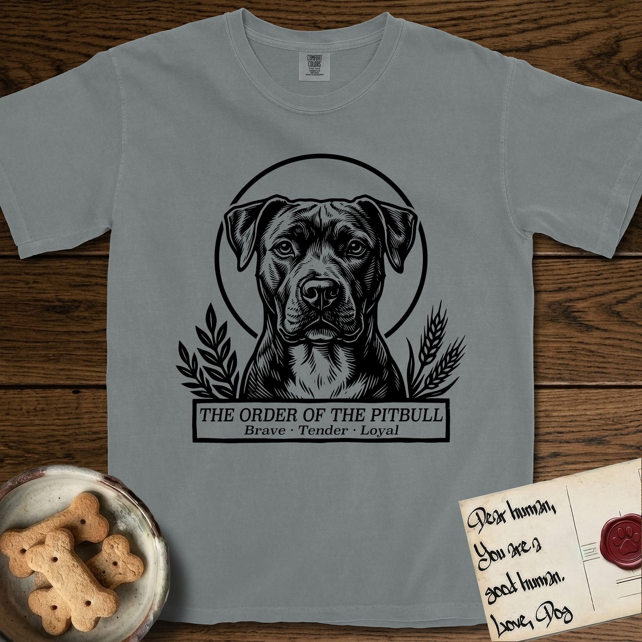 Holy Orders Pitbull T-Shirt flat lay in Granite, featuring a bold black-and-white linocut saint-medallion portrait of a Pitbull.