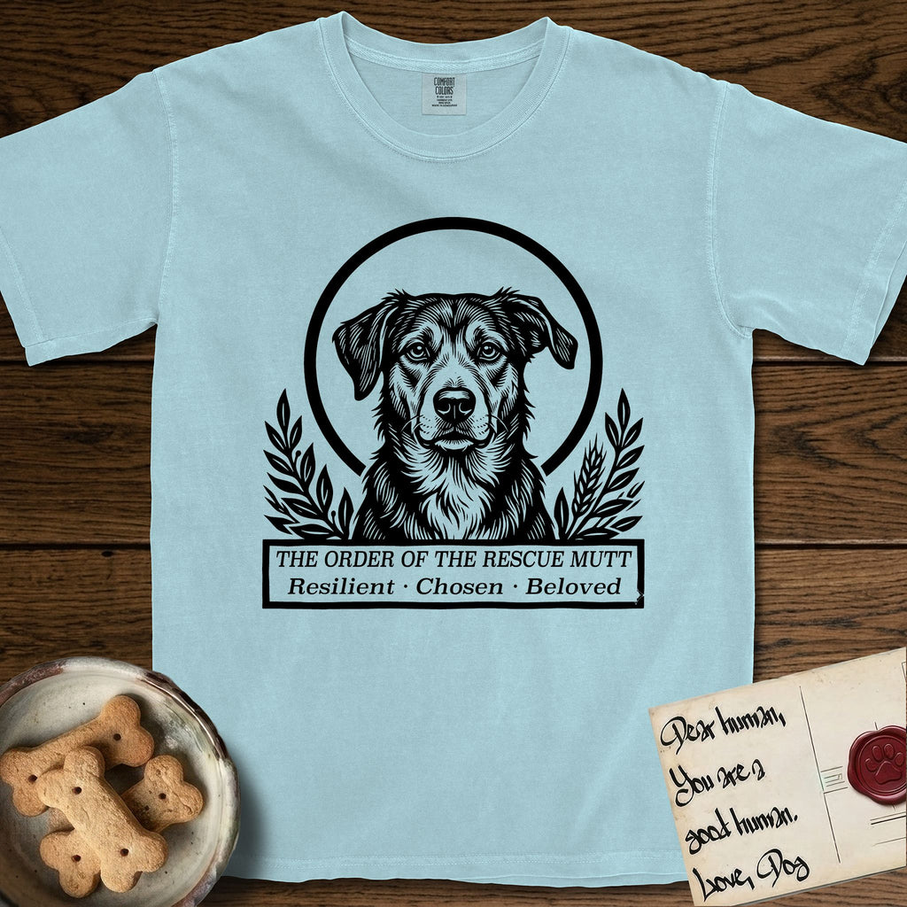 Holy Orders Rescue Mutt T-Shirt flat lay in Chambray, featuring a bold black-and-white linocut saint-medallion portrait of a rescue mutt.