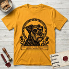 Holy Orders Schnauzer T-Shirt flat lay in Gold, featuring a bold black-and-white linocut saint-medallion portrait of a Schnauzer.
