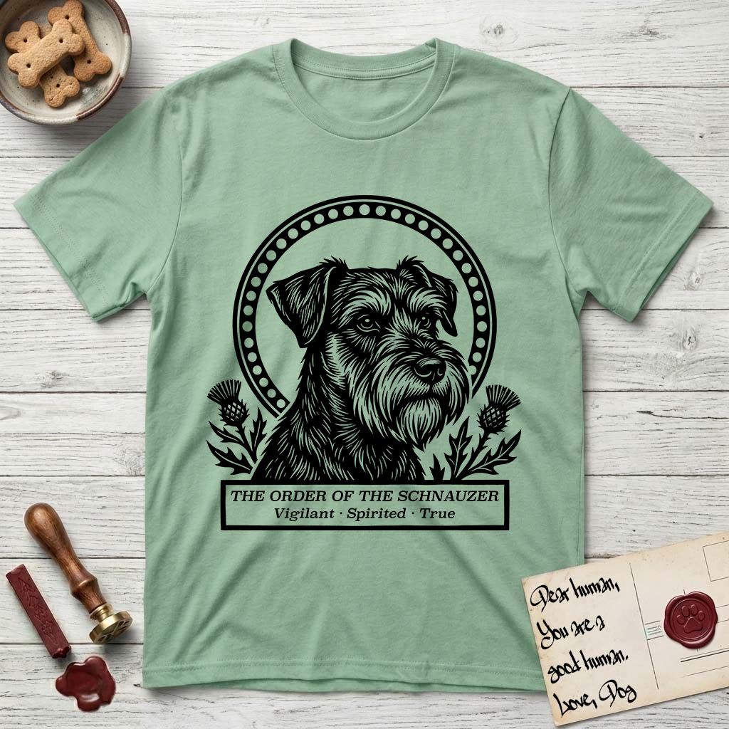 Holy Orders Schnauzer T-Shirt flat lay in Mint Green, featuring a bold black-and-white linocut saint-medallion portrait of a Schnauzer.
