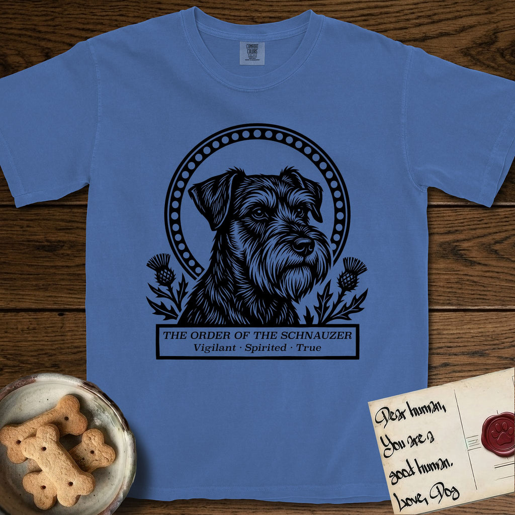 Holy Orders Schnauzer T-Shirt flat lay in Mystic Blue, featuring a bold black-and-white linocut saint-medallion portrait of a Schnauzer.
