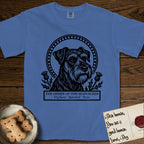 Holy Orders Schnauzer T-Shirt flat lay in Mystic Blue, featuring a bold black-and-white linocut saint-medallion portrait of a Schnauzer.