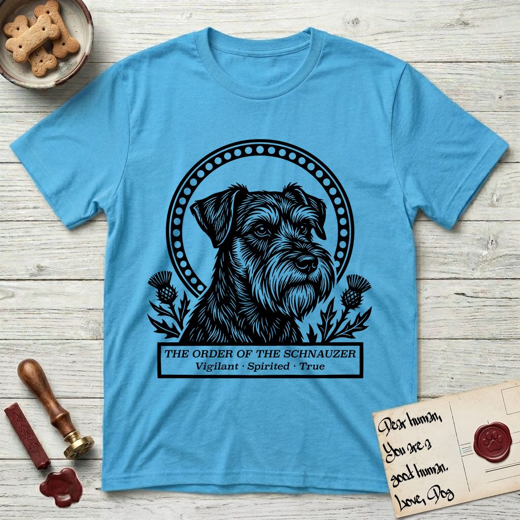 Holy Orders Schnauzer T-Shirt flat lay in Sky, featuring a bold black-and-white linocut saint-medallion portrait of a Schnauzer.