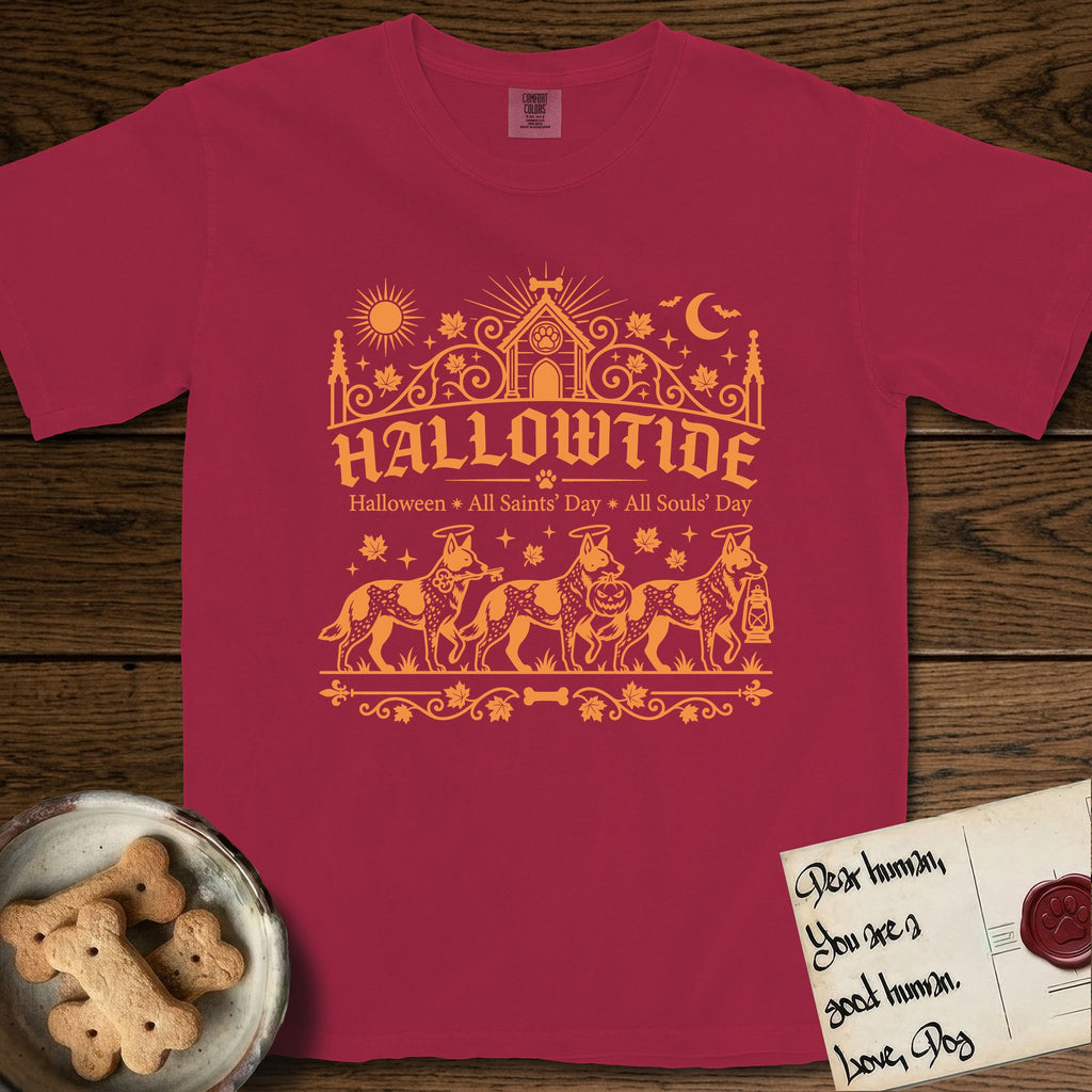 Hallowtide Australian Cattle Dog T-Shirt flat lay in Chili, featuring Orange one-color gothic illustration of three haloed speckled Australian Cattle Dogs walking in procession carrying a skeleton key, a scary jack-o'-lantern, and an iron lantern, under the blackletter headline HALLOWTIDE.