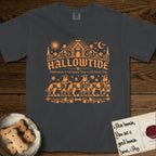 Hallowtide Australian Cattle Dog T-Shirt flat lay in Graphite, featuring Orange one-color gothic illustration of three haloed speckled Australian Cattle Dogs walking in procession carrying a skeleton key, a scary jack-o'-lantern, and an iron lantern, under the blackletter headline HALLOWTIDE.