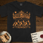 Hallowtide Australian Shepherd T-Shirt flat lay in Black, featuring Orange one-color gothic illustration of three haloed merle Australian Shepherds walking in procession carrying a skeleton key, a scary jack-o'-lantern, and an iron lantern, under the blackletter headline HALLOWTIDE.