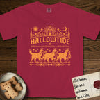 Hallowtide Bernese Mountain Dog T-Shirt flat lay in Chili, featuring Orange one-color gothic illustration of three haloed Bernese Mountain Dogs walking in procession carrying a skeleton key, a scary jack-o'-lantern, and an iron lantern, under the blackletter headline HALLOWTIDE.