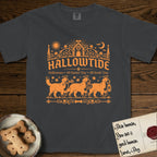 Hallowtide Bernese Mountain Dog T-Shirt flat lay in Graphite, featuring Orange one-color gothic illustration of three haloed Bernese Mountain Dogs walking in procession carrying a skeleton key, a scary jack-o'-lantern, and an iron lantern, under the blackletter headline HALLOWTIDE.