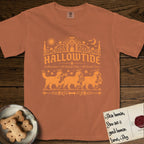 Hallowtide Bernese Mountain Dog T-Shirt flat lay in Yam, featuring Orange one-color gothic illustration of three haloed Bernese Mountain Dogs walking in procession carrying a skeleton key, a scary jack-o'-lantern, and an iron lantern, under the blackletter headline HALLOWTIDE.