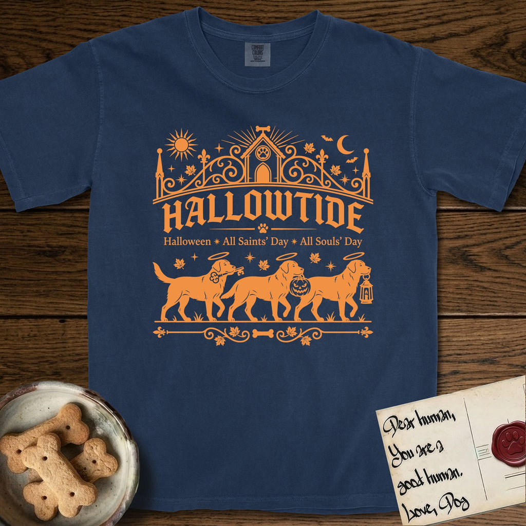 Hallowtide Black Lab T-Shirt flat lay in True Navy, featuring Orange one-color gothic illustration of three haloed Black Labs walking in procession carrying a skeleton key, a scary jack-o'-lantern, and an iron lantern, under the blackletter headline HALLOWTIDE.