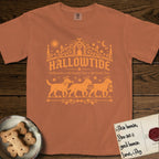 Hallowtide Black Lab T-Shirt flat lay in Yam, featuring Orange one-color gothic illustration of three haloed Black Labs walking in procession carrying a skeleton key, a scary jack-o'-lantern, and an iron lantern, under the blackletter headline HALLOWTIDE.