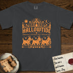 Hallowtide Cairn Terrier T-Shirt flat lay in Graphite, featuring Orange one-color gothic illustration of three haloed shaggy Cairn Terriers walking in procession carrying a skeleton key, a scary jack-o'-lantern, and an iron lantern, under the blackletter headline HALLOWTIDE.
