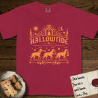 Hallowtide Doberman T-Shirt flat lay in Chili, featuring Orange one-color gothic illustration of three haloed Dobermans walking in procession carrying a skeleton key, a scary jack-o'-lantern, and an iron lantern, under the blackletter headline HALLOWTIDE.