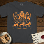 Hallowtide Doberman T-Shirt flat lay in Graphite, featuring Orange one-color gothic illustration of three haloed Dobermans walking in procession carrying a skeleton key, a scary jack-o'-lantern, and an iron lantern, under the blackletter headline HALLOWTIDE.