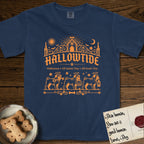 Hallowtide Pug T-Shirt flat lay in True Navy, featuring Orange one-color gothic illustration of three haloed curly-tailed Pugs walking in procession carrying a skeleton key, a scary jack-o'-lantern, and an iron lantern, under the blackletter headline HALLOWTIDE.