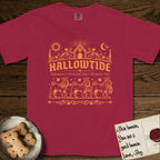 Hallowtide Shar-Pei T-Shirt flat lay in Chili, featuring Orange one-color gothic illustration of three haloed wrinkled Shar-Peis walking in procession carrying a skeleton key, a scary jack-o'-lantern, and an iron lantern, under the blackletter headline HALLOWTIDE.