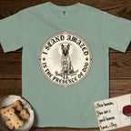 I Stand Amazed in the Presence Belgian Malinois T-Shirt flat lay in Bay, featuring a vintage engraving medallion of a haloed Belgian Malinois with a small devoted human gazing up from below.