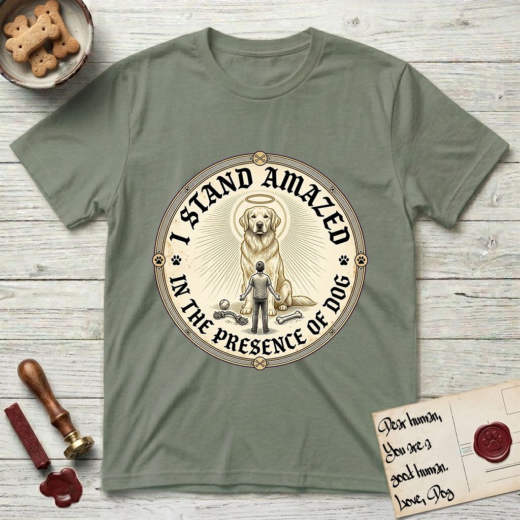 I Stand Amazed in the Presence Golden Retriever T-Shirt flat lay in Sage, featuring a vintage engraving medallion of a haloed Golden Retriever with a small devoted human gazing up from below.