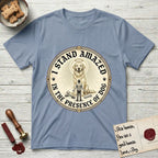I Stand Amazed in the Presence Golden Retriever T-Shirt flat lay in Stone Blue, featuring a vintage engraving medallion of a haloed Golden Retriever with a small devoted human gazing up from below.
