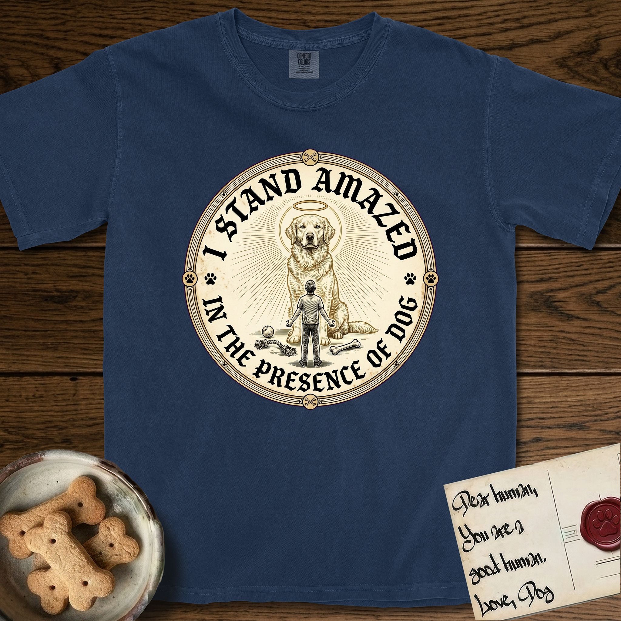 I Stand Amazed in the Presence Golden Retriever T-Shirt flat lay in True Navy, featuring a vintage engraving medallion of a haloed Golden Retriever with a small devoted human gazing up from below.